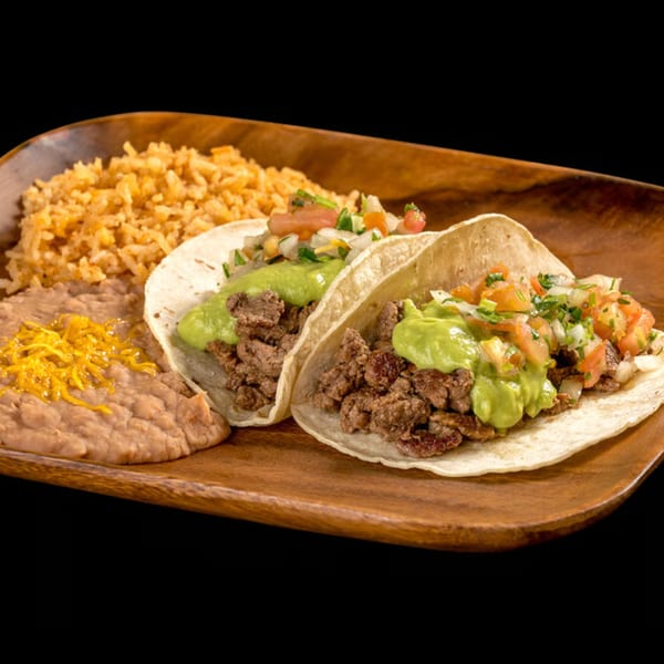 Two carne asada tacos with guacamole and pico de gallo, served with rice and refried beans.